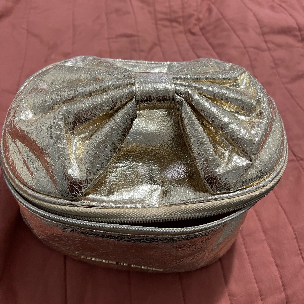 Victoria’s Secret Gold Makeup bag with bow handle detail.